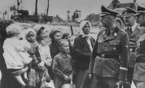Гиммлер (на переднем плане) разговаривает с жителями деревни Новинки во время инспекционной поездки по Белоруссии